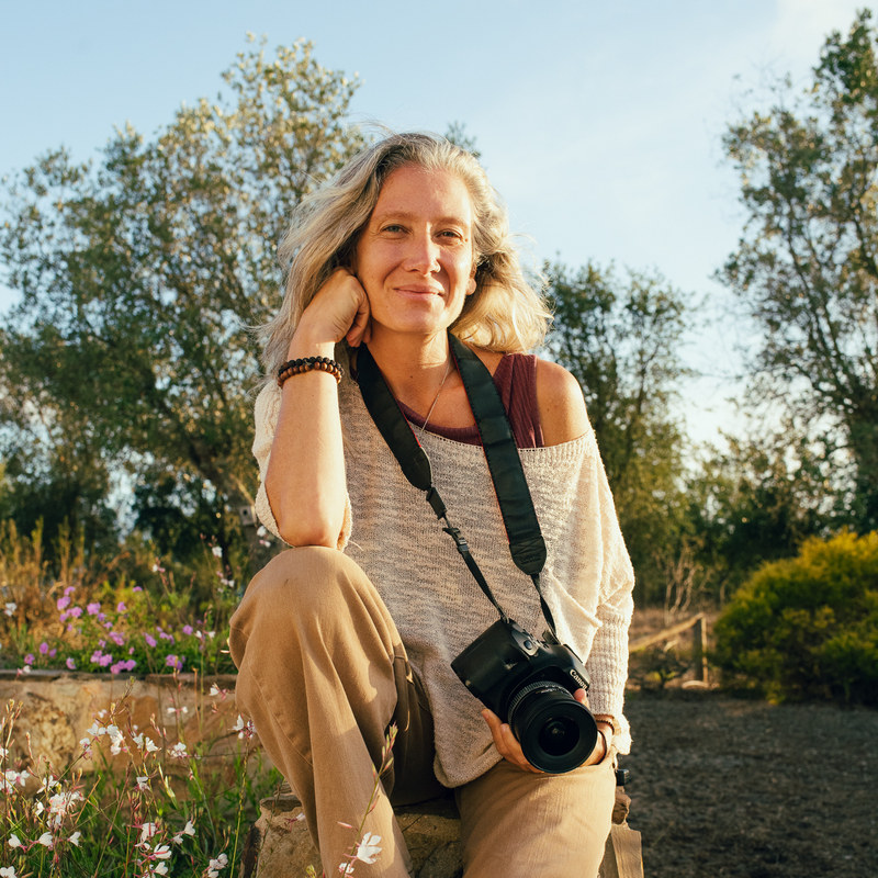 Jyoti Graziano outdoors at golden hour, her camera in her lap