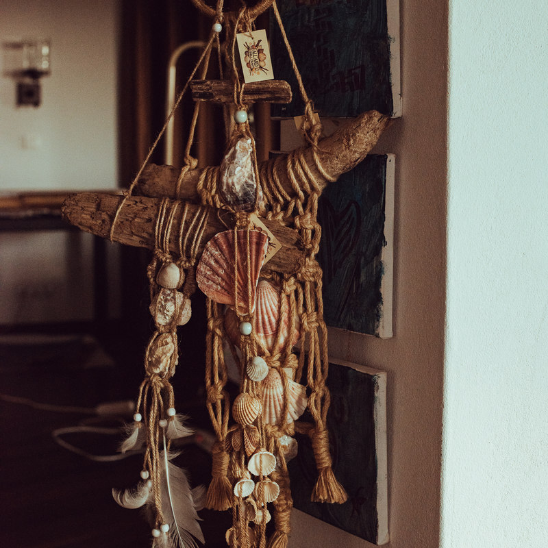 A totem of shells, feathers and driftwood hanging in the doorway