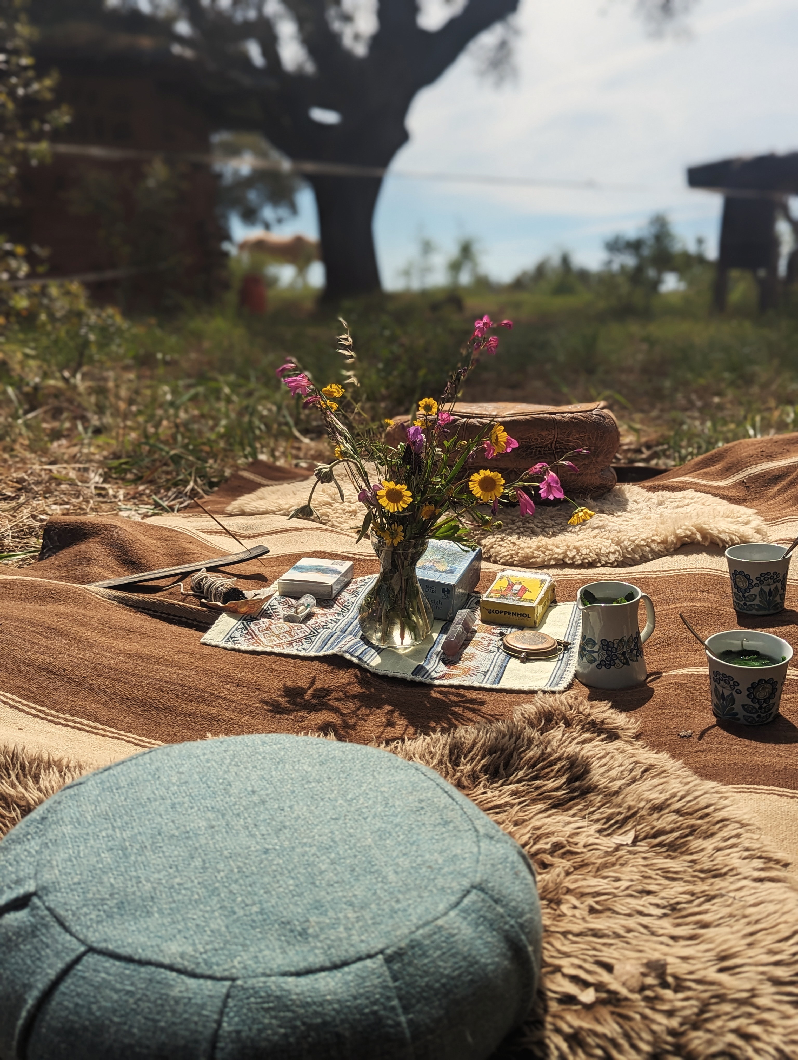 A ritual altar of tarot cards, crystals, and wildflowers in the meadow