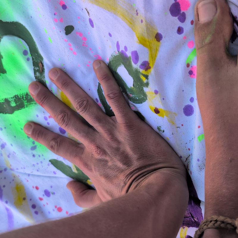 Painted hands and feet on a cloth covered in colour