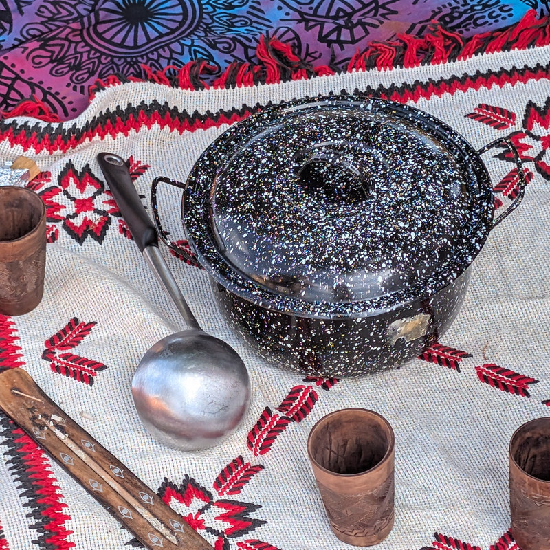 Shankari's cacao pot and cups laid out on an embroidered cloth